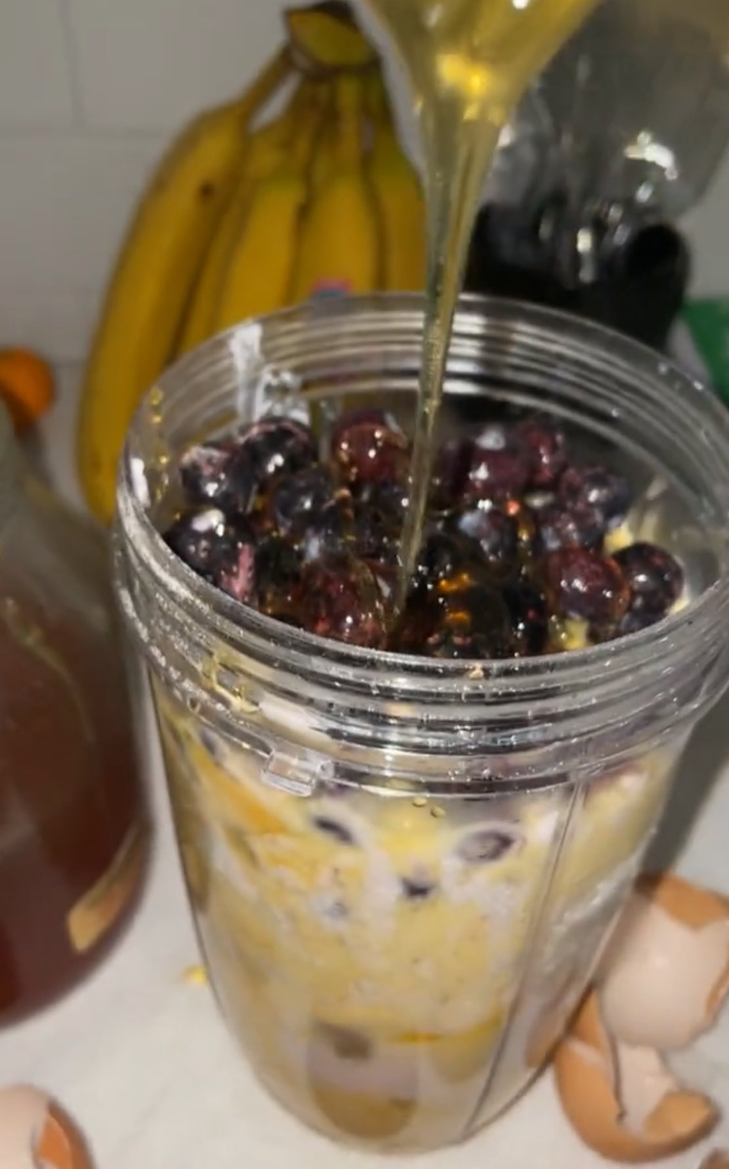 a honey smoothie in a cup with bananas in background